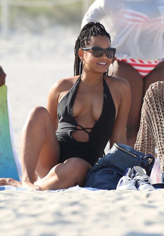 Met atletisch lichaam en Zwart haartype zonder BH(cup)  op het strand in bikini
